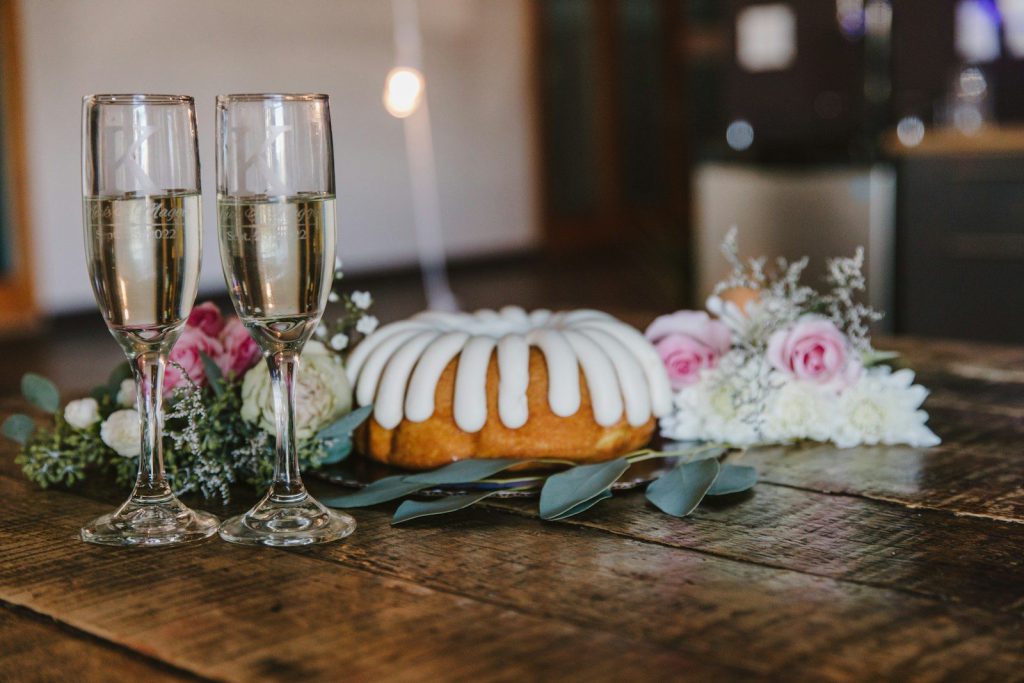 Chiếc bánh và hai ly rượu trên bàn gỗ
