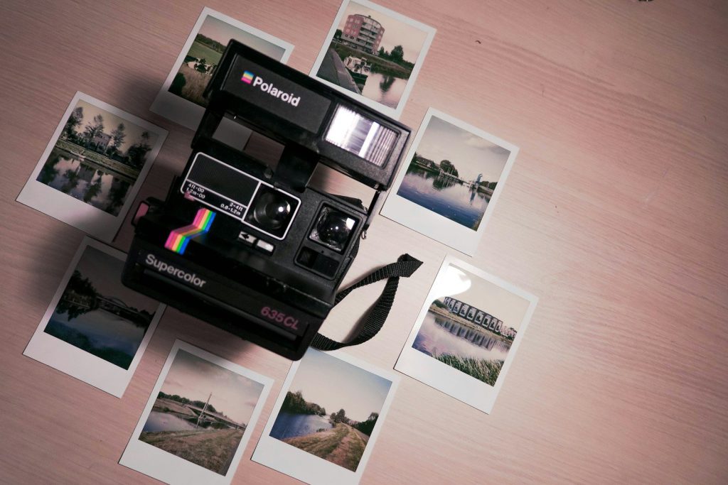 Máy ảnh Polaroid và những tấm ảnh in rải trên bàn